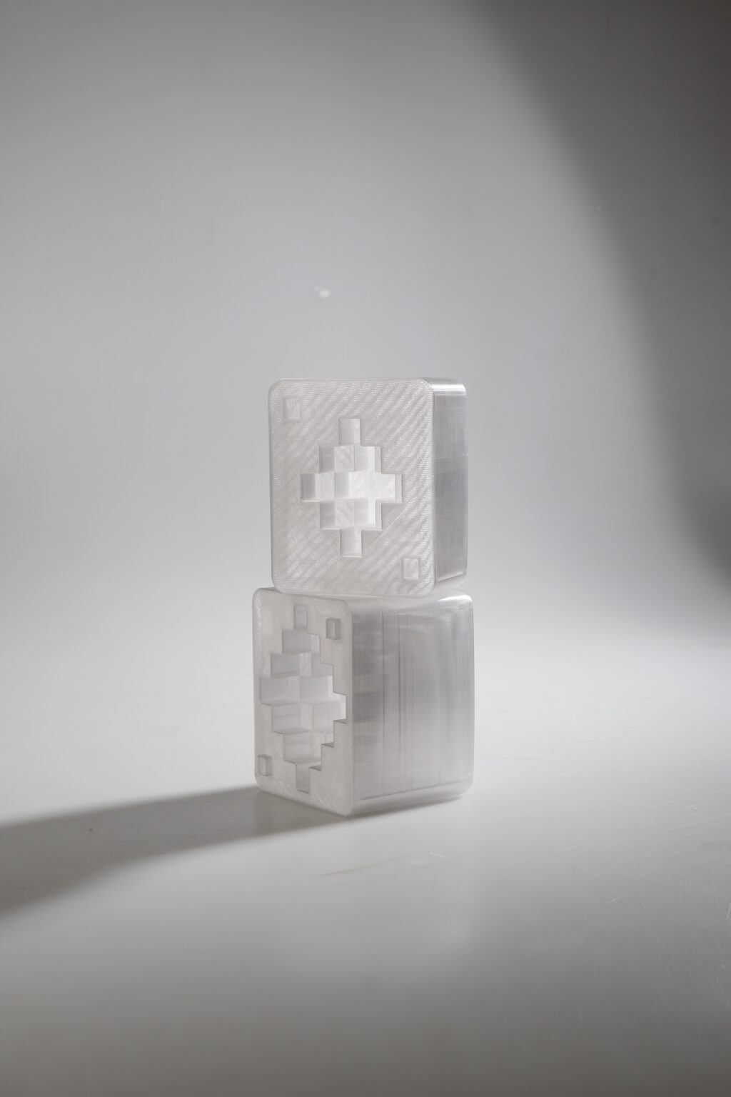 The designer's glass sugar bowl is based on the Czech invention of sugar cubes and transforms this symbol associated with dining into the contemporary form of an art object. The sugar bowl is created using the fused sculpture technique and consists of a lower part and a lid. The inner cavity of the sugar bowl resembles layered sugar cubes. After connecting the two parts, a geometric formation resembling a crystal is created through the clear glass.

The object connects the tradition of Czech glassmaking with the playfulness of building from cubes and refers to the purity, openness and hospitality associated with dining. The symbol of the sugar cube functions here as an unobtrusive cultural reference to the Czech invention and the everyday ritual of sharing at the table.